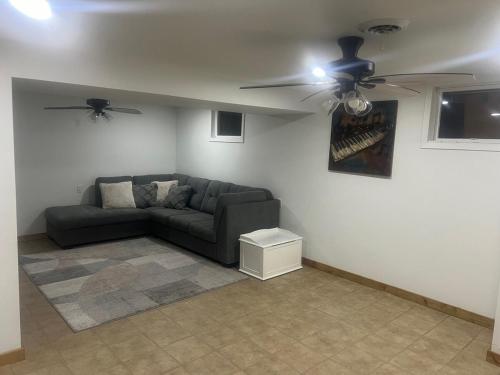 un soggiorno con un divano e un ventilatore a soffitto di Bosco Bluff Cottage a Lansing