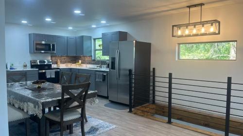 una cucina con tavolo e frigorifero in acciaio inox di Bosco Bluff Cottage a Lansing