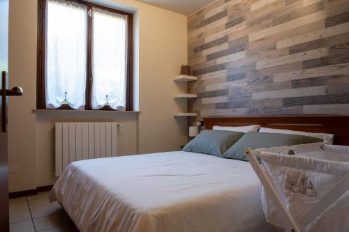 Un dormitorio con una cama y una pared de madera. en Appartamento Margherita, en Porto Valtravaglia