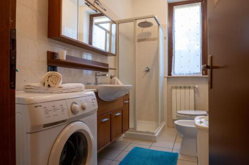 Un baño con lavadora y lavabo. en Appartamento Margherita, en Porto Valtravaglia