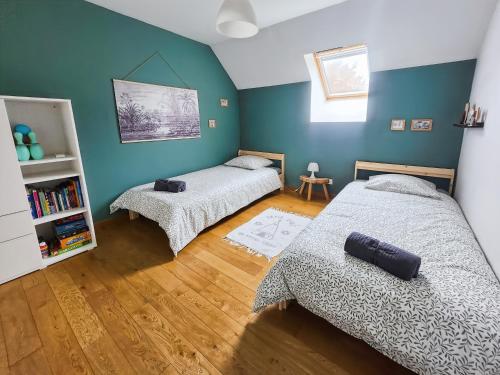 two beds in a room with blue walls and wooden floors at Maison Cosy Campagne, Spacieuse, Terrasse in Le Plessis-Feu-Aussoux