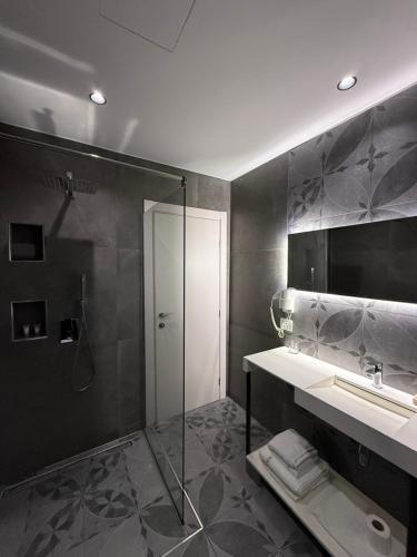 a bathroom with a shower and a sink and a mirror at Maxi Room in Vlorë