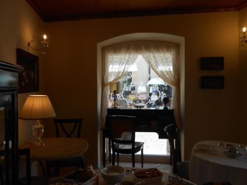 a room with a table and a window with a piano at Ca' Ottocento in Lazise