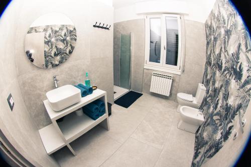 a bathroom with a sink and a toilet and a mirror at Villa nel Parco dei Ronchi in Legnano