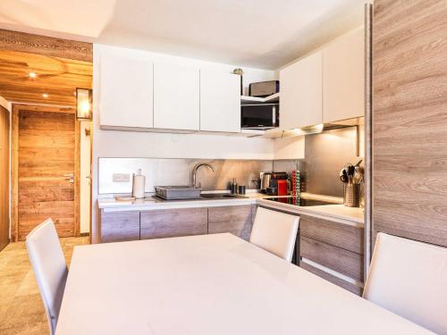 une cuisine avec une table blanche et des armoires blanches dans l'établissement Duplex vue panoramique Proche pistes Garage prive, à Montgenèvre