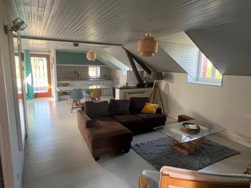a living room with a couch and a table at Maison calme et chaleureuse au coeur du Béarn in Berenx