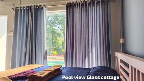a bedroom with a bed and a large window at River view adventures in Dandeli