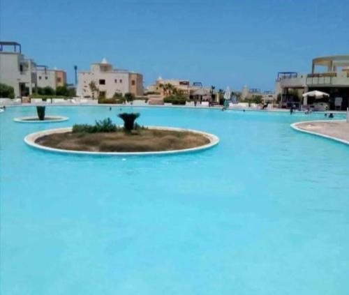 a small island in the middle of a swimming pool at شاليه ديمورا عائلات فقط Dimora Chalet Only Family in Dawwār Muḩammad Abū Shunaynah