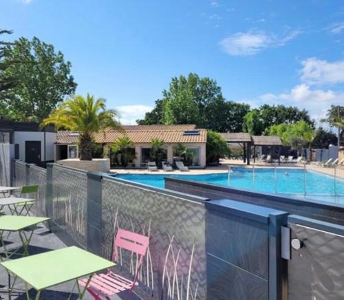 un balcon avec une piscine avec tables et chaises dans l'établissement L aube, à La Bernerie-en-Retz