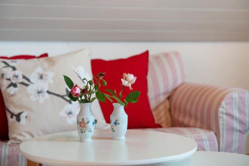 two vases with flowers on a table with a couch at Joos Boardinghouse in Radolfzell am Bodensee