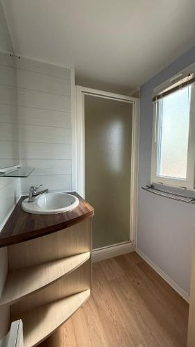 une salle de bain avec un lavabo et une fenêtre dans l'établissement L aube, à La Bernerie-en-Retz