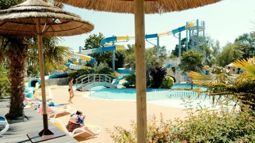 un parc aquatique avec un toboggan et des toboggans dans l'établissement Camping de La Piscine, à Fouesnant