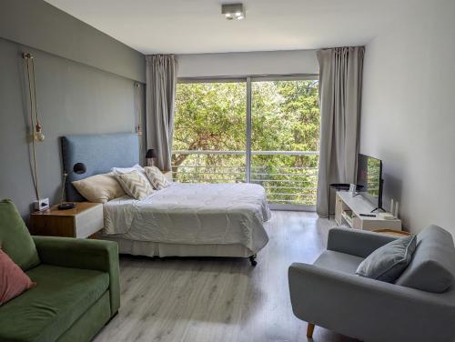 a bedroom with a bed and a couch and a window at iDeal Concord Pilar Aparts in Pilar