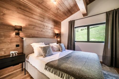 une chambre avec un lit et un mur en bois dans l'établissement Apartment Cerna Les Houches - by EMERALD STAY, aux Houches