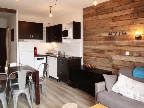 Il comprend une cuisine et un salon avec un mur en bois. dans l'établissement Appartement standing 6/7p avec piscine, sauna, hammam, wifi, animaux admis - Les Orres 1800 - FR-1-322-99, aux Orres
