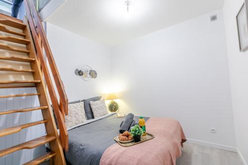 une petite chambre avec un lit et un escalier dans l'établissement L'authentique au coeur de Paris, à Paris
