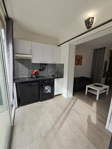 une cuisine avec une machine à laver dans une pièce dans l'établissement Jardin Amirante - Élégance & calme à Sanary, à Sanary-sur-Mer