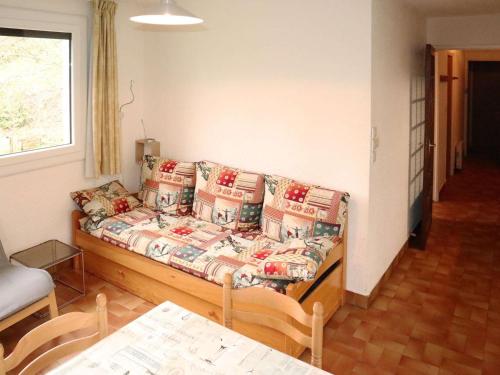 un salon avec un canapé et une table dans l'établissement Appt skis aux pieds avec parking, balcon, 4 lits, animaux acceptés - FR-1-322-154, aux Orres