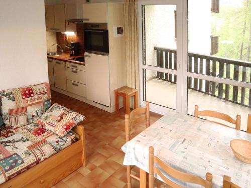 un salon avec un canapé et une table et une cuisine dans l'établissement Appt skis aux pieds avec parking, balcon, 4 lits, animaux acceptés - FR-1-322-154, aux Orres