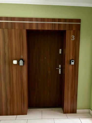 two wooden doors in a building with the number three at Lakeside Promenade View Studios in Ostróda