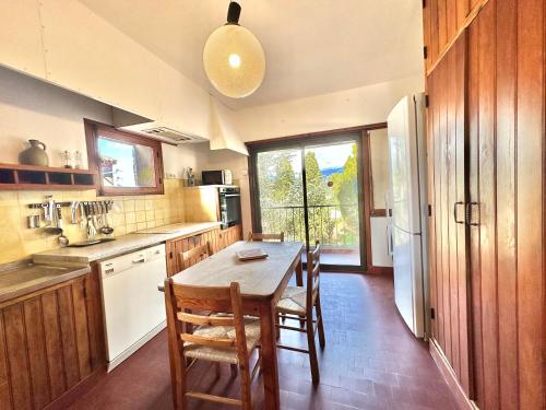 une cuisine avec une table, des chaises et un réfrigérateur dans l'établissement Villa de charme vue imprenable sur le golfe, 6 pers PORTO-VECCHIO, à Porto-Vecchio