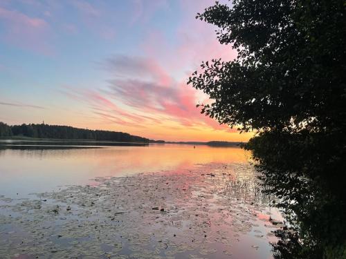 a view of a lake with a sunset in the background at Lakeside Promenade View Studios in Ostróda