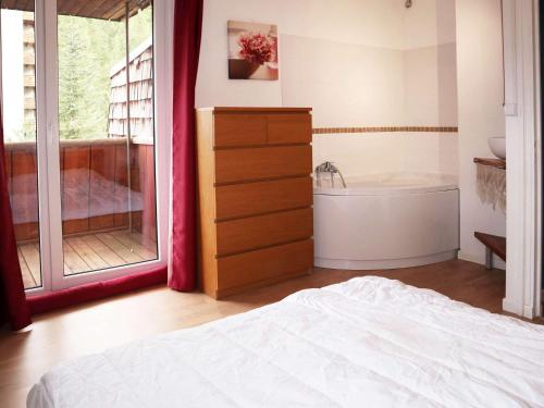 sypialnia z łóżkiem i wanną w obiekcie Appart 2 pièces 6-8 pers, accès direct pistes - FR-1-322-514 w mieście Les Orres