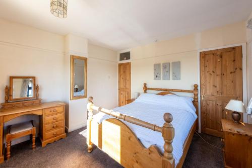 ein Schlafzimmer mit einem Holzbett und einer Holzkommode in der Unterkunft The Cottage - Holiday home in Reedham on the Southern Norfolk Broads in Reedham