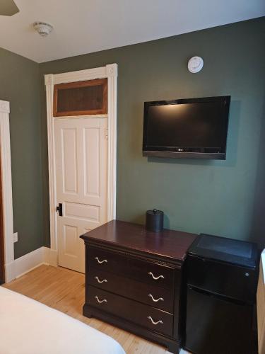 a bedroom with a dresser and a flat screen tv at Albany Merchants Hotel in Albany