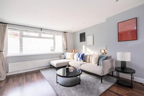 a living room with a couch and a table at Excellent 3 bed House Hyde Park in London