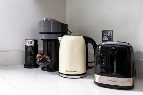 a coffee maker and a toaster on a counter at Excellent 3 bed House Hyde Park in London