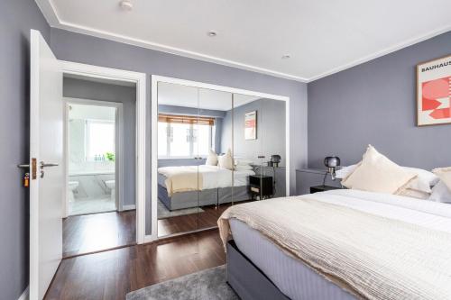 a bedroom with a large bed and a mirror at Excellent 3 bed House Hyde Park in London