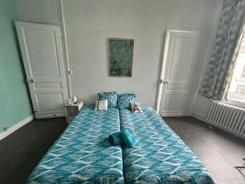 une chambre avec un grand lit avec une couette bleue dans l'établissement Suite Fleurus, à Lille