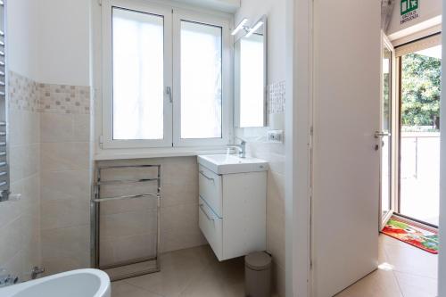 a white bathroom with a sink and a window at casa di Stefano in Rome