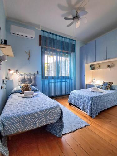 a bedroom with two beds and a ceiling fan at Villa Sabry in Turriaco