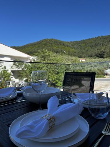 a table with plates and wine glasses on it at Siesta Thassos - Luxury Apartment in Skala Rachoniou