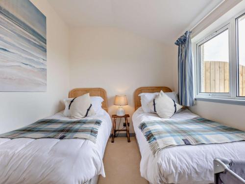 two twin beds in a room with a window at 3 Bed in Montrose 90784 in Inverkeilor