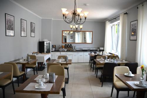 a restaurant with tables and chairs and a kitchen at D&D Hotel by Wiggers in Bad Oldesloe