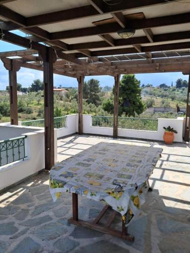 a table on top of a patio with a roof at Aylida House in Paralía Avlídhos