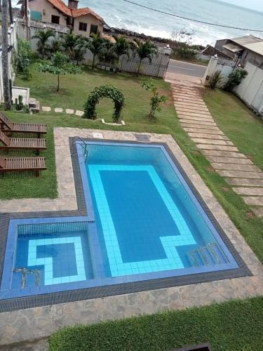 a swimming pool in a yard next to a house at Isamar beach front in Marawila