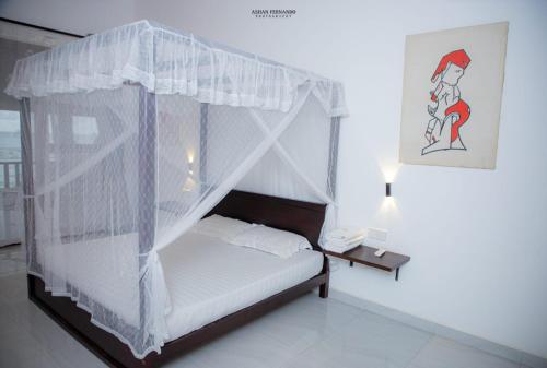 a bed with a canopy in a room at Isamar beach front in Marawila