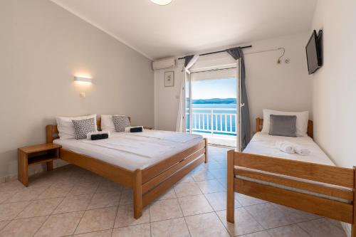 a bedroom with two beds and a large window at Villa Belvedere in Lokva Rogoznica