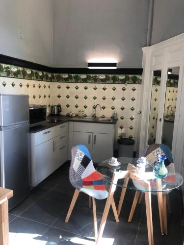 Il comprend une cuisine équipée d'une table, de 2 chaises, d'une table et d'un réfrigérateur. dans l'établissement Appartement T2 52 m2 l'Ambassadeur centre-ville 1 chambre balcon, à Aix-les-Bains