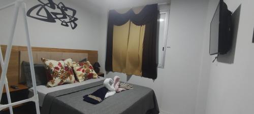 a room with two beds with a doll laying on them at Pé na Areia Gonzaguinha Perto de Tudo in São Vicente