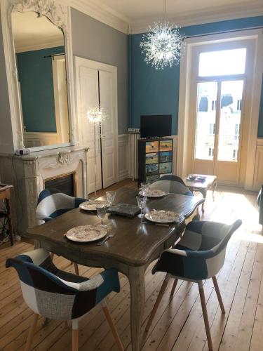 une salle à manger avec une table et des chaises en bois dans l'établissement Appartement T2 52 m2 l'Ambassadeur centre-ville 1 chambre balcon, à Aix-les-Bains