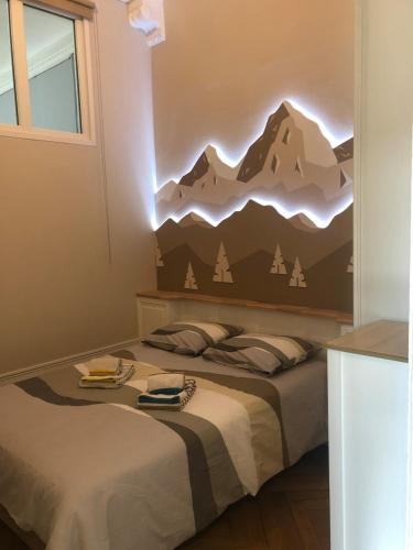 - une chambre avec un lit orné d'une fresque murale représentant la montagne dans l'établissement Appartement T2 52 m2 l'Ambassadeur centre-ville 1 chambre balcon, à Aix-les-Bains