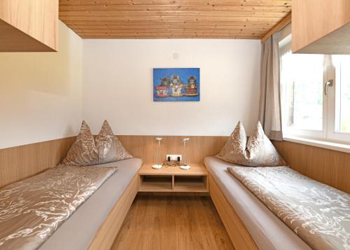 two beds in a small room with a window at Ferienwohnungen Schantl in Schoppernau