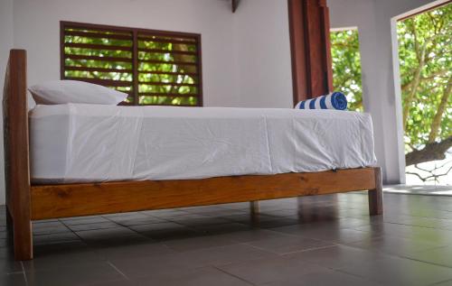a bed with white sheets on it in a room at Dany Island in Luganville