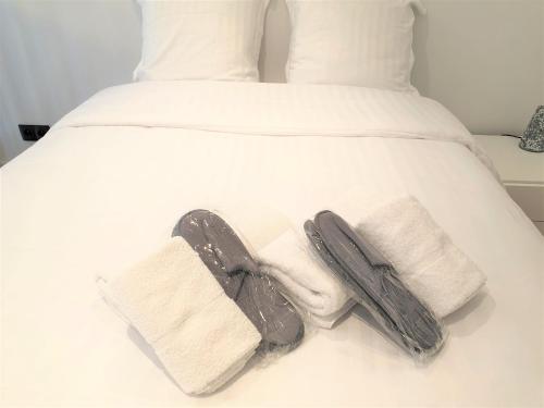 - une paire de chaussures et de serviettes sur un lit dans l'établissement BAIE DES ANGES DUPLEX 205, à Nice