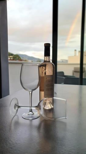 une bouteille de vin et un verre sur une table dans l'établissement Modern Top-Floor Apartment with Terrace, Pool & Free Private Parking, à Roquebrune-Cap-Martin